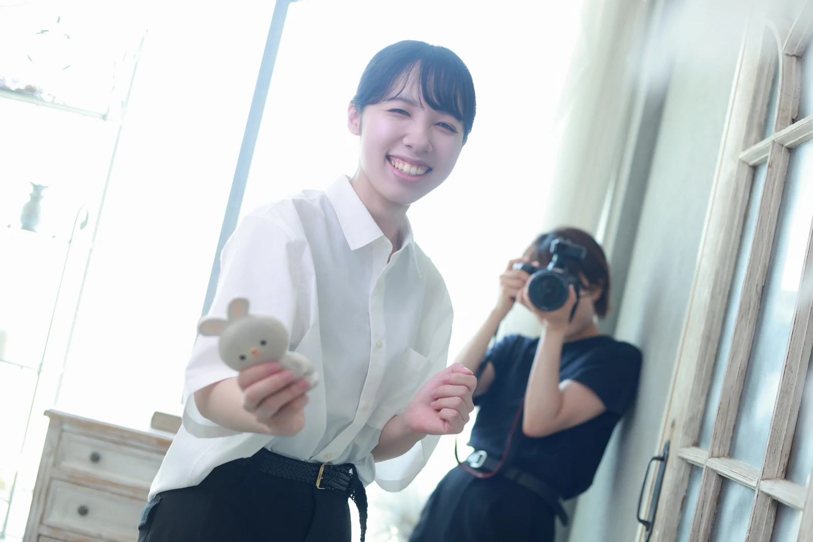 ぬいぐるみを手に笑顔で撮影を支えるフォトグラファーアシスタント